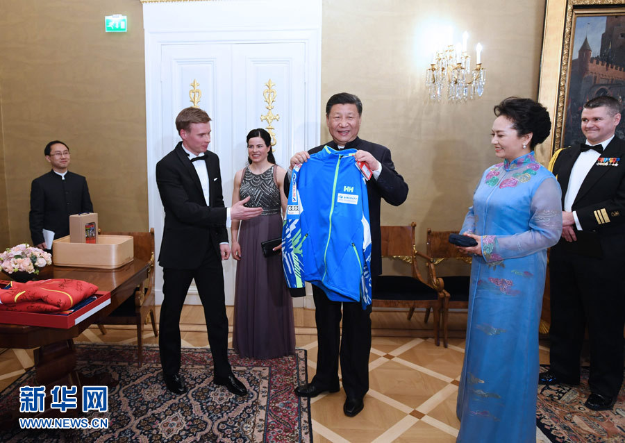 當地時間4月5日晚，國家主席習近平和芬蘭總統尼尼斯托在赫爾辛基共同會見剛剛參加完2017年世界花樣滑冰錦標賽的中芬兩國冰雪運動員代表。習近平夫人彭麗媛和尼尼斯托夫人豪吉歐參加會見。這是芬蘭運動員向習近平和夫人彭麗媛贈送運動衣。新華社記者 饒愛民 攝